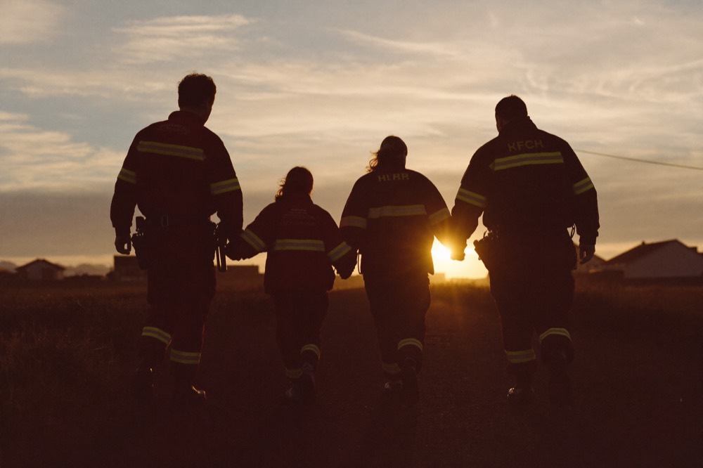 A first responder family walking together toward the sunrise
