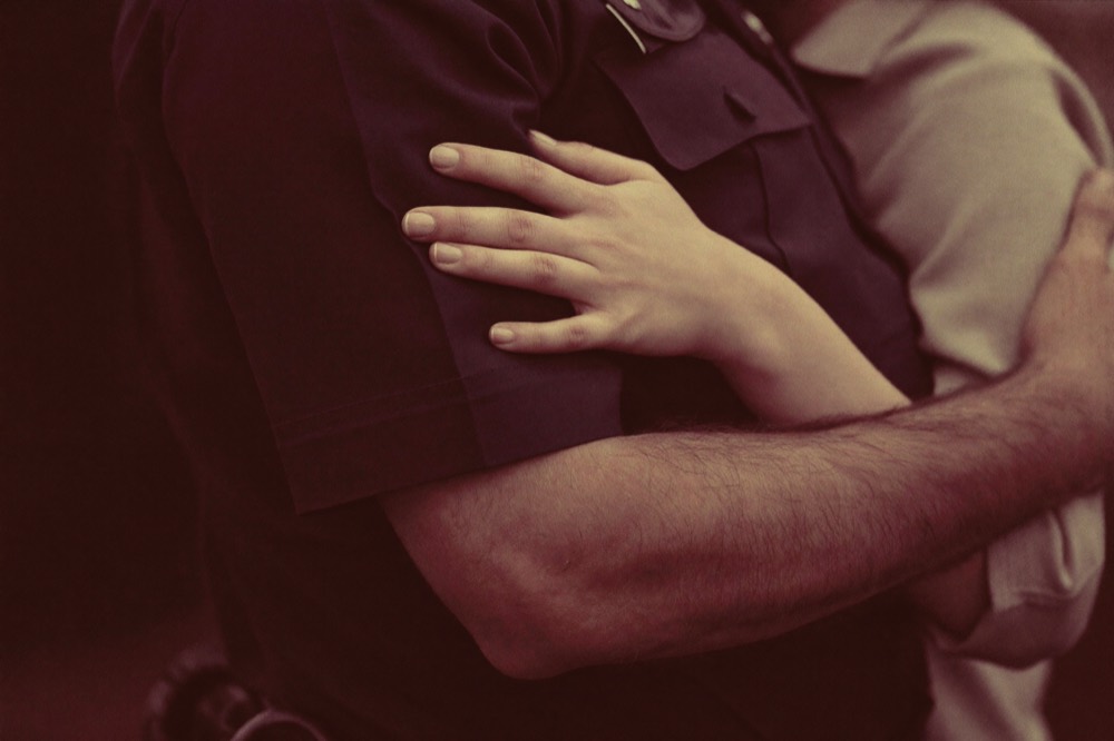 A police officer with a supportive arm around a community member